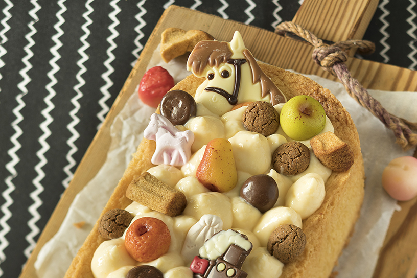 Speculaaspoppen in een mandje met koffie op de achtergrond